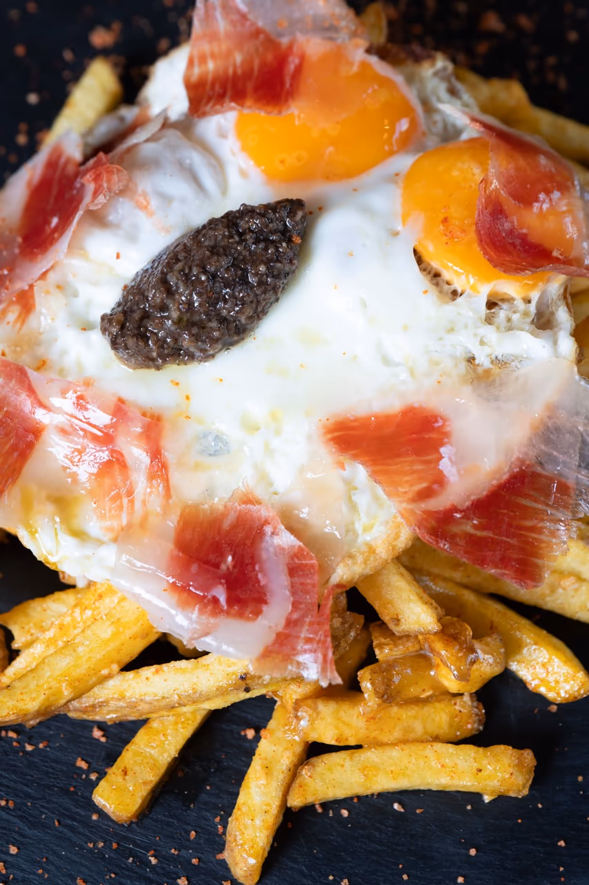 Huevos de corral con trufa y jamón sobre patatas