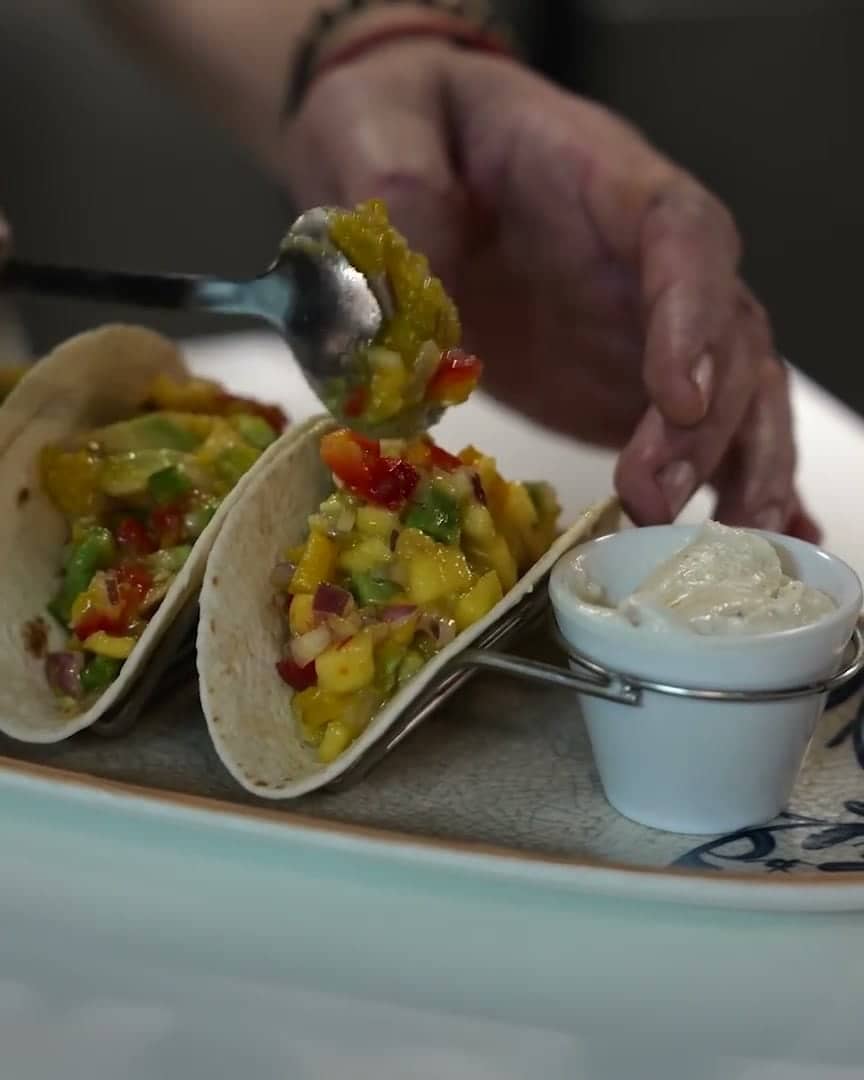Manos emplatando tacos vegetales en Paprika Realejo